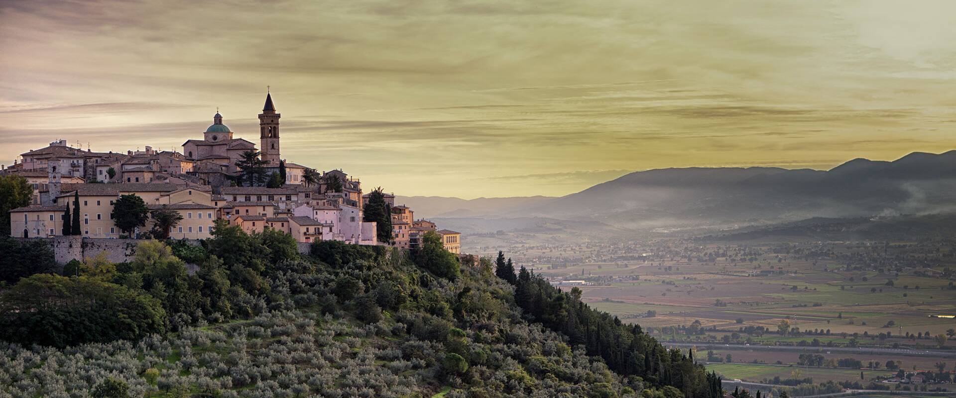Medieval hilltop town overlooking the Umbrian valley at sunset